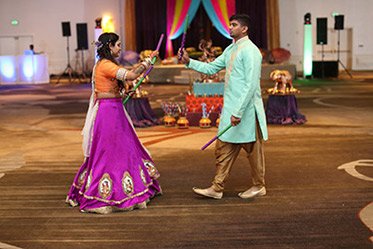 Indian Bride and Groom Playing Dandiya Raas