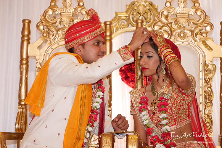 Indian Groom applying Sindoor to the Bride