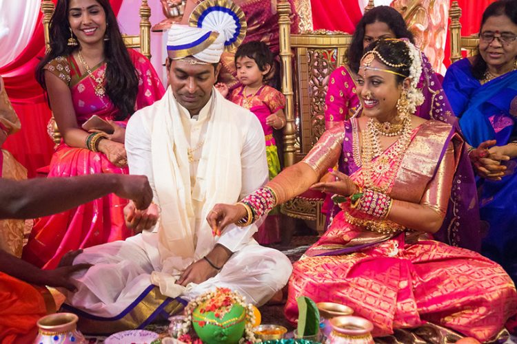 Indian Bride and Groom Putting Grains on Coconut