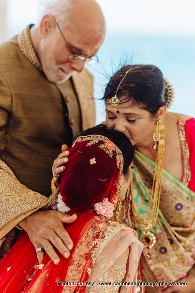 Mother kissing Indian bride on the forehead