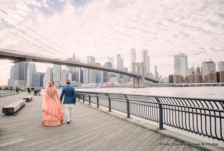 Indian Bride and Groom walking on bridge with holding hands