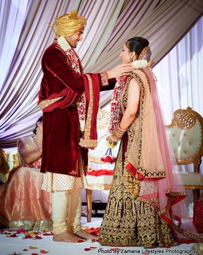 Indian groom putting a flower garland to his bride