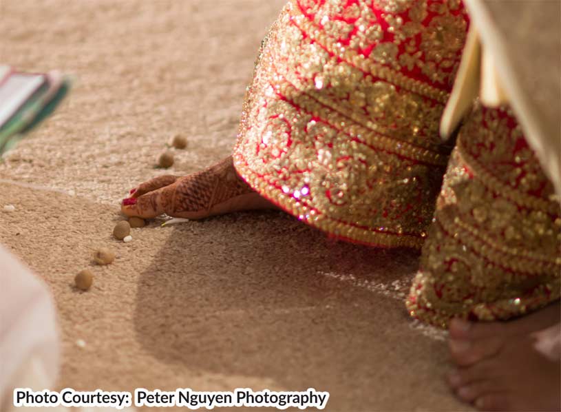 groom leads the first three Pheras around the fire