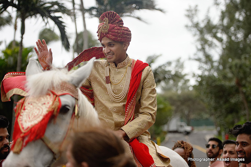 Indian groom riding on a horse at the baraat