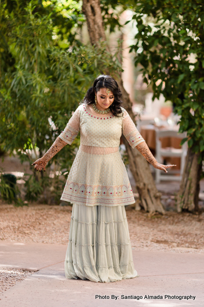 Radiant new Indian bride savoring the moment in her mehandi outfit