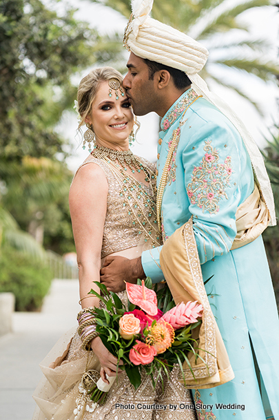 Indian groom kissing bride