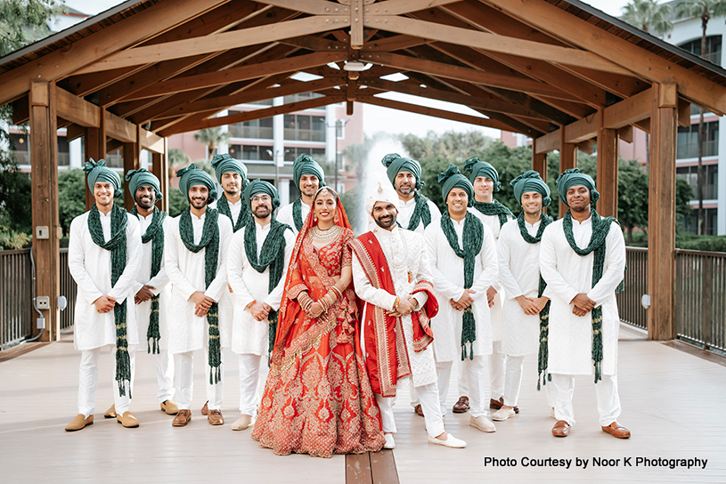Indian bride and groom posing for photoshoot with groomsmen