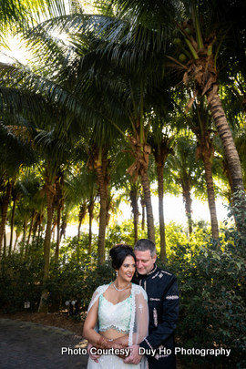 Outdoor wedding photoshoot featuring ocean waves, blue skies, and vibrant décor