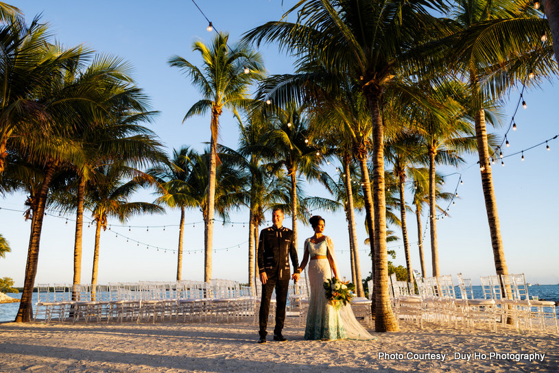 Wide-angle shot of the couple in a dreamy outdoor setting near the ocean Wide-angle shot of the couple in a dreamy outdoor setting near the ocean
