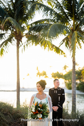 Scenic outdoor photoshoot with soft waves and greenery framing the couple