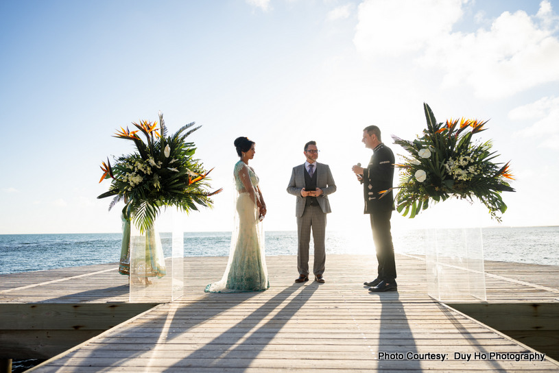 Bride’s flowing dress and groom’s suit captured beautifully in an outdoor setting by the water Bride’s flowing dress and groom’s suit captured beautifully in an outdoor setting by the water