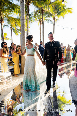 Couple dressed in elegant wedding outfits during their outdoor beach ceremony