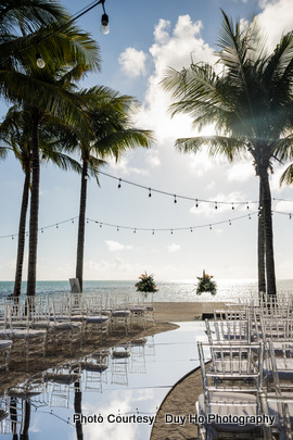 Wedding ceremony setup with floral decorations and ocean views in the background