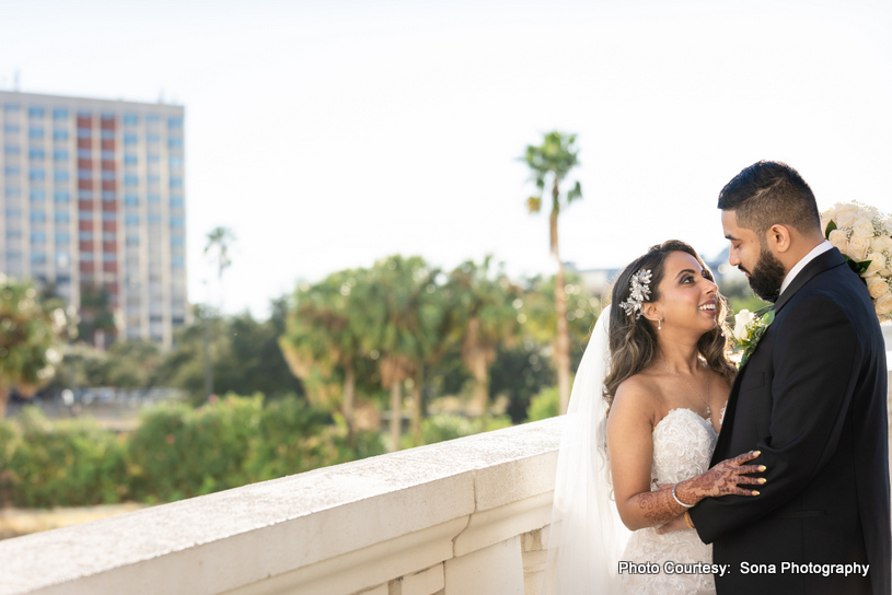 Outdoor portrait of the couple capturing their cultural elegance amidst a garden backdrop