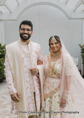 A close portrait of a happy couple dressed in ornate Indian wedding clothing, celebrating their special day.