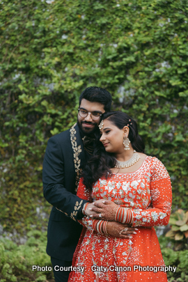 Ami and Vinny posing outdoors with lush greenery in the background