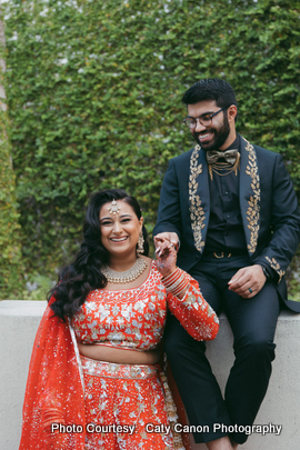 Ami and Vinny posing outdoors with lush greenery in the background