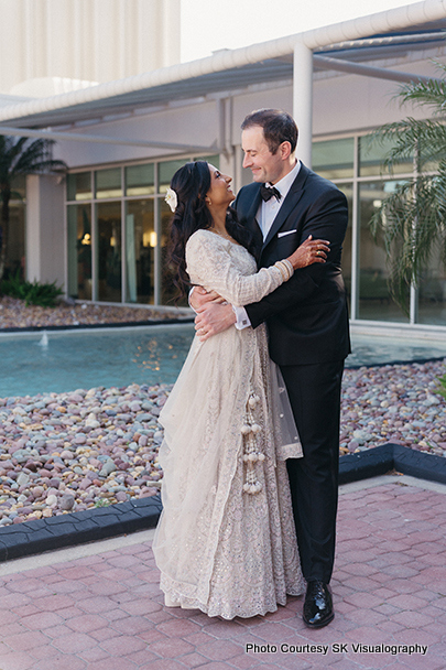 Sujata and Mark embracing each other near a fountain during wedding photoshoot