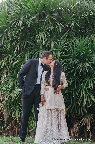 Sujata and Mark sharing a romantic kiss outdoors during wedding photoshoot
