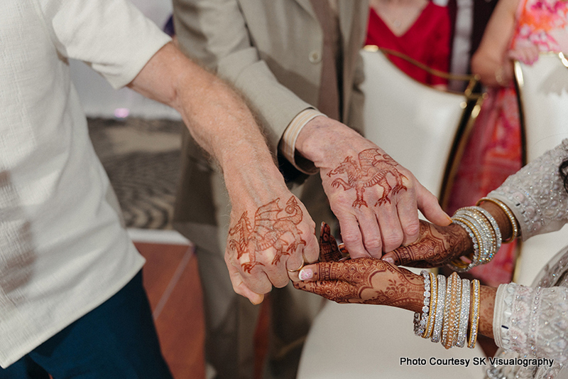 Close up of Sujata and Mark performing traditional Indian wedding ritual with hands